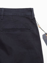 Close-up of dark navy trousers by Blue de Gênes, featuring a back welt pocket, belt loops, and visible tag attached by a string. Made from comfort stretch fabric for ease and style, the Menzo Dobby Chino design enhances their smooth, well-crafted appeal.