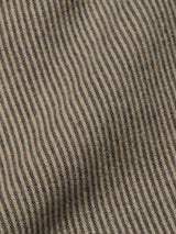 Close-up of the Ginotto Oregon Shirt - Pebble Beige by Blue de Gênes, showing a yarn-dye stripe with thin vertical black and beige hues. Made from brushed cotton, the fabric has a slightly textured surface with subtle undulations creating shadows and highlights.