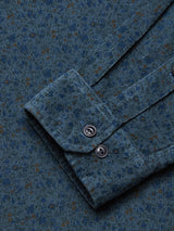 A close-up of the Enrico Cord Shirt by Blue de Gênes showcases textured teal baby corduroy with small brown dots, featuring a cuff with two silver buttons, visible stitching, and a soft, slightly ribbed texture.