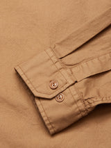 Close-up of a Blue de Gênes Enrico Nidos Shirt - Fudge sleeve in cotton piqué; garment-dyed with two brown buttons on the cuff and visible stitching to accentuate texture.
