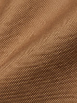 Close-up of the Enrico Nidos Shirt - Fudge by Blue de Gênes. Its textured brown cotton piqué fabric, with a waffle-like pattern, shows subtle folds and lighting variations, highlighting the intricacies of the garment-dyed material.