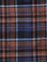 Close-up of the Zamboni Quadro Shirt by Blue de Gênes, highlighting its navy check yarn-dye pattern in blue, black, and brown squares. A pocket seamlessly blends with the soft, woven texture of this winter cotton-linen blend fabric.