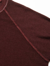 Close-up of the Marlon Knit - Prune by Blue de Gênes highlights the shoulder seam and reverse knit pattern with fine texture. The Merino wool blend offers a luxurious finish, making seam lines stand out against the dark background.