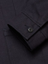 Close-up of the Amos Blazer - Dark Navy by Blue de Gênes, featuring a relaxed fit, cotton canvas fabric, visible stitching, and a single black cuff button.