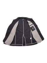 The Amos Blazer - Dark Navy by Blue de Gênes is shown inside-out, revealing light gray lining, visible seams, a label on the inner left, and a white tag at the lower right. The sleeves and collar are partially visible.