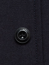 Close-up of the Amos Blazer - Dark Navy by Blue de Gênes, showing its cotton canvas fabric and a black button engraved with the brand name.