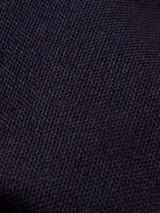 Close-up of the Amos Blazer - Dark Navy by Blue de Gênes, highlighting its textured, dark navy woven fabric with a visible grid-like pattern and slightly rough surface.