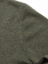 Close-up of Blue de Gênes Monte AW Knit - Forest, featuring green textile with a seam and textured slubby yarn appearance, highlighting the stitching detail reminiscent of a cozy crewneck jumper.