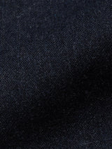 A close-up of a textured dark navy fabric, like the premium Italian wool blend seen in Blue de Gênes Canna Santo Gilet. The rich color and soft fibers offer warmth and coziness, evoking fine Portuguese tailoring.