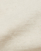 Close-up of Abramo Desk Shorts - Natural from Blue de Gênes, featuring light beige textured fabric with a woven pattern. Likely a cotton/linen blend, the material appears soft and flexible with thread variations.