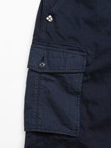 Close-up of the navy Paulino Cargo Shorts by Blue de Gênes features a flap pocket with a button, echoing utility designs. A small metallic logo accents the lightweight, textured fabric, enhancing its versatile military-inspired look.