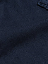 Close-up of the navy denim fabric of Paulino Cargo Shorts by Blue de Gênes, highlighting the texture and weave pattern like sturdy military cotton. A small black label with white text is partially visible at the top right corner.