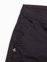 Close-up of Menzino Shorts - Dark Navy from Blue de Gênes featuring visible side pocket, prominent stitching on lightweight garment-dyed fabric, a small metal emblem near the pocket, and a slightly red inner waistband.