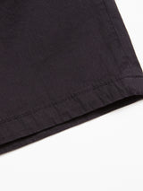 Close-up of the hem of Blue de Gênes Menzino Shorts in Dark Navy against a white background, showcasing the smooth herringbone fabric and subtle stitching along the edge.