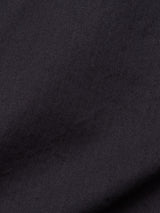 A close-up of the dark navy garment-dyed fabric with a diagonal herringbone pattern reveals fine, parallel lines, reminiscent of the precision found in Blue de Gênes Menzino Shorts.