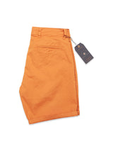 The Menzino Shorts - Apricot by Blue de Gênes are crafted from herringbone fabric with a garment-dyed finish, featuring a single back pocket and belt loops, with a tag attached at the waistband.