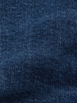 Close-up of mid blue comfort stretch denim from Repi Roll Jeans by Blue de Gênes, showcasing the textured weave. The fabrics surface reveals subtle color variations and a slightly faded look, typical of this material.