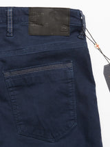 Close-up of the Repi Grasso Jeans - Navy by Blue de Gênes, featuring a dark blue regular slim-fit design with classic five-pocket style. A leather Repi Jeans label decorates the waistband, complemented by a hanging tag. Visible stitching on the back pocket and waistband highlights the detailed texture.