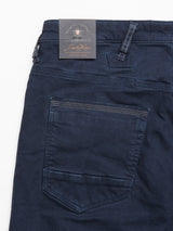 Blue de Gênes Repi Grasso Jeans in navy are slim-fit with a back pocket, contrast stitching, and a grey tag displaying text and a logo on the belt loop. These classic five-pocket jeans are stylishly laid flat on a white background.