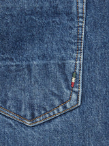 This close-up of Blue de Gênes Giacomo Maracas Jeans - Vintage Wash showcases a pocket with orange stitching, embodying Italian craftsmanship, with a small green, white, and red thread detail accentuating the upper right corner.