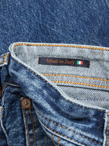 Close-up of Giacomo Maracas Jeans - Vintage Wash by Blue de Gênes, highlighting Italian craftsmanship. The interior label states Made in Italy with the Italian flag. These relaxed-fit jeans feature orange stitching and a metal button.