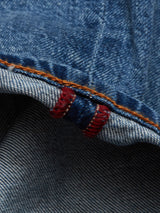 A close-up of Vinci Super Used Jeans by Blue de Gênes shows comfort stretch denim with orange stitching. The hem has a red thread accent, adding contrast. Expertly crafted in Italy, the blue denims texture and weaving pattern are clearly visible.