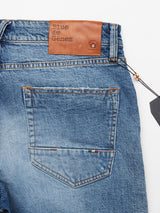 The Vinci Super Used Jeans by Blue de Gênes are expertly crafted in Italy, featuring a comfort stretch denim in light washed fabric with a brown leather patch displaying the text Blue de Gênes. They include visible stitching on the back pocket and a dark tag on the belt loop.