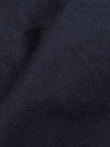 A close-up of the Mustang Cargo Pant - Navy by Blue de Gênes reveals a soft, dark blue fabric with slight folds, akin to parachute cotton. The smooth and uniform color is ideal for durable cargo pants.