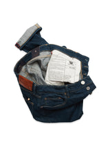 The Blue de Gênes Vinci Topaz Jeans - Rinse Wash, crafted in Italy, feature dark blue jeans turned inside out to reveal a lighter denim interior and care label, complete with a leather patch, metal buttons, multiple pockets, and Comfort Stretch Denim for comfort.