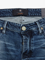 Close-up of Vinci Denova Jeans by Blue de Gênes, featuring a visible waistband, belt loops, and button closure. These expertly crafted in Italy, regular fit jeans offer comfort stretch denim with a faded appearance and a partial view of a black tag inside.