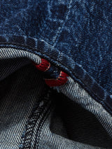 A close-up of the seam on Vinci Denova Jeans by Blue de Gênes features dark blue comfort stretch denim contrasted with a lighter striped underside and red stitching, expertly crafted in Italy.