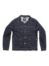 The Cosimo Trucker Jacket by Blue de Gênes blends classic western vibes with modern style, featuring long sleeves, a button-up front, and contrast stitching on dark blue denim. It has two chest pockets with button flaps, two side pockets, and a spread collar for a timeless look.