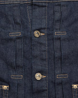 Close-up of a Blue de Gênes Cosimo Trucker Jacket - Dark Blue Denim, highlighting two metal buttons, orange stitching, and elegant vertical seams with perfectly aligned buttonholes.