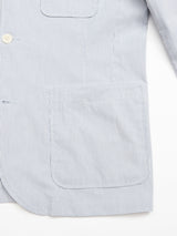 The Gabbiano Riga Blazer by Blue de Gênes showcases a relaxed fit in light blue pinstripe cotton yarn dye stripe fabric. Featuring a patch pocket and visible button, its vertical pattern offers a subtle, effortless style.