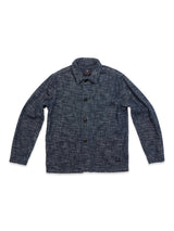 The Kojima Jacket - Navy by Blue de Gênes, inspired by Japanese workwear, is displayed on a white background. It has a button-up design, long sleeves, and collar with a grid-like pattern for an authentic look.