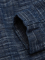 Close-up of the Kojima Jacket - Navy by Blue de Gênes, featuring blue tweed fabric with white speckles. The sleeve corner highlights the texture and pattern, reminiscent of Japanese workwear, giving it a lived-in look typical of a classic janitor jacket.