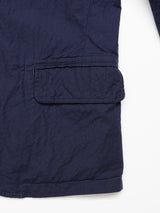 Close-up of the Gervaso Tarlo Blazer in navy from Blue de Gênes, featuring a blue cotton fabric with a rectangular closed flap pocket. The textured, slightly wrinkled material shows visible stitching along the seams.