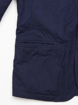 Close-up of the Gervaso Tarlo Blazer - Navy by Blue de Gênes, featuring a sleeve and pocket detail. The textured cotton fabric showcases visible stitching, corozo buttons, and a horizontal pocket opening against a white background.