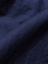 Close-up of the Gervaso Tarlo Blazer - Navy by Blue de Gênes. Crafted from dark blue cotton fabric with a soft texture, the materials gentle folds and woven pattern create subtle shadows. Featuring corozo buttons, its ideal for a sleek blazer highlighted by its rich, deep color and smooth surface.