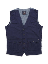 The Ludovico Tarlo Gilet - Navy by Blue de Gênes features a deep V-neck, button closure, and two flap pockets. Its crinkled cotton fabric reveals a dark blue interior at the edges, with an elegant Blue de Gênes flag pin for a stylish touch.