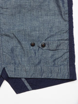 Close-up of the Ludovico Tarlo Gilet - Navy by Blue de Gênes, featuring a textured, slightly wrinkled chambray fabric hem with two buttons and a side slit with overlapping material.