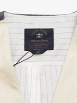 A close-up shows a Pantella Desk Gilet collar with a dark label inside, featuring an emblem and Porto Cervo, Blue de Gênes, plus the size 50. The Cotton/Linen lining has thin stripes, and Corozo buttons with a black string looped through the label enhance its elegance.