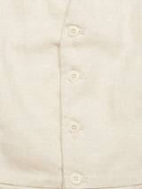 Close-up of the Pantella Desk Gilet - Natural by Blue de Gênes, crafted from a cotton/linen blend fabric. It features five Corozo buttons down the front, showcasing visible stitching and a textured appearance.