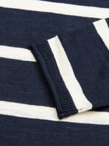 Close-up of Blue de Gênes Monte Stripe Knit - Navy, featuring a dark blue crewneck with white stripes and a folded sleeve. The knit fabrics texture is clear, crafted from a cotton/linen blend.