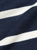 Close-up of the Monte Stripe Knit - Navy by Blue de Gênes, featuring textured navy blue fabric with horizontal white stripes. The slightly wrinkled cotton/linen blend emphasizes the contrast between dark blue and white, resembling a classic crewneck jumper.