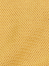The Filo Knit Polo - Yellow Grain by Blue de Gênes features a yellow waffle-textured fabric with a retro grid-like pattern, crafted from 100% cotton for a soft and evenly woven surface.