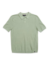 The Filo Knit Polo in Green Bay by Blue de Gênes is a 100% cotton light green polo with short sleeves, a collar, textured pattern, and retro repeat stitch design on the buttoned placket, laid flat on a white background.