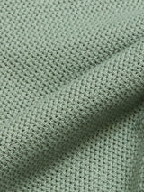 A detailed view of the Filo Knit Polo in Green Bay by Blue de Gênes highlights its waffle-textured light green fabric, crafted from 100% cotton, revealing intricate patterns and soft folds.