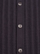 Close-up of the Compra Open Polo Knit - Dark Navy by Blue de Gênes, featuring a dark cable-knit texture with a vertical row of corozo nut buttons in the center, highlighting its intricate design.