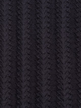 Close-up of the Compra Open Polo Knit - Dark Navy by Blue de Gênes, featuring textured dark navy fabric crafted from organic cotton with a repeating chevron pattern creating v-shaped grooves for a ribbed, retro stitch look.